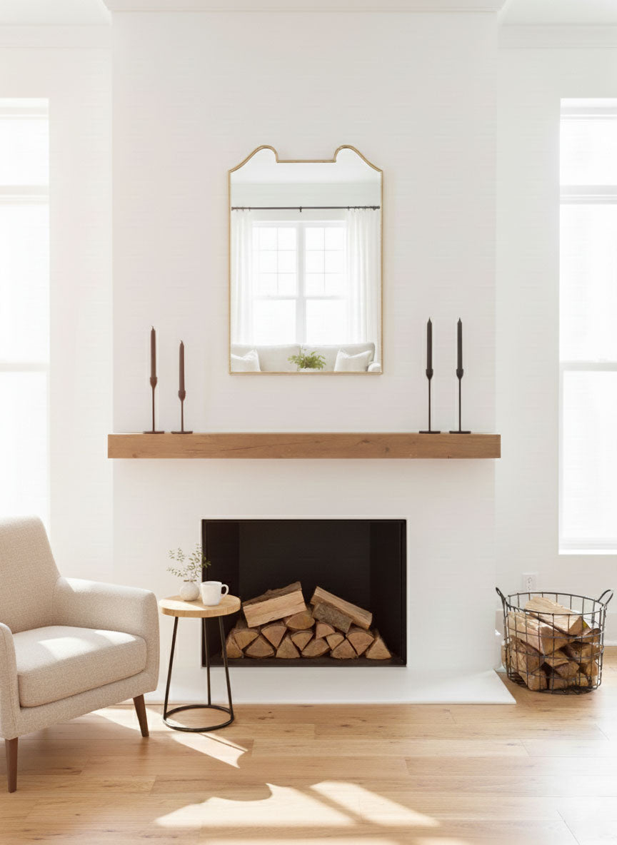 Double arch crest brass mirror above fireplace mantel