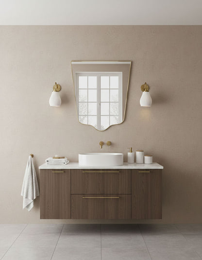 Minimal crest-edge brass mirror in modern bathroom with warm neutral tones