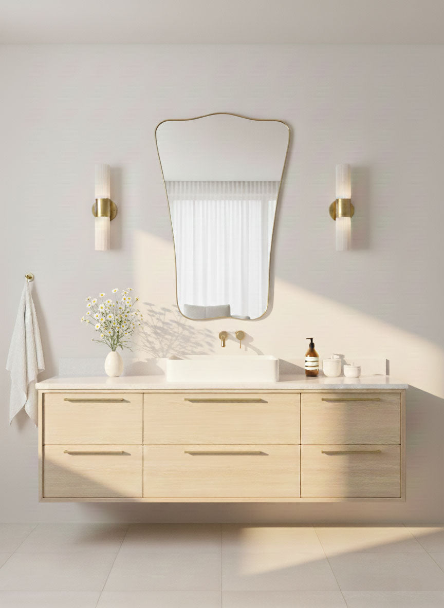 Butterfly wave mirror with curved brass frame in bright modern bathroom
