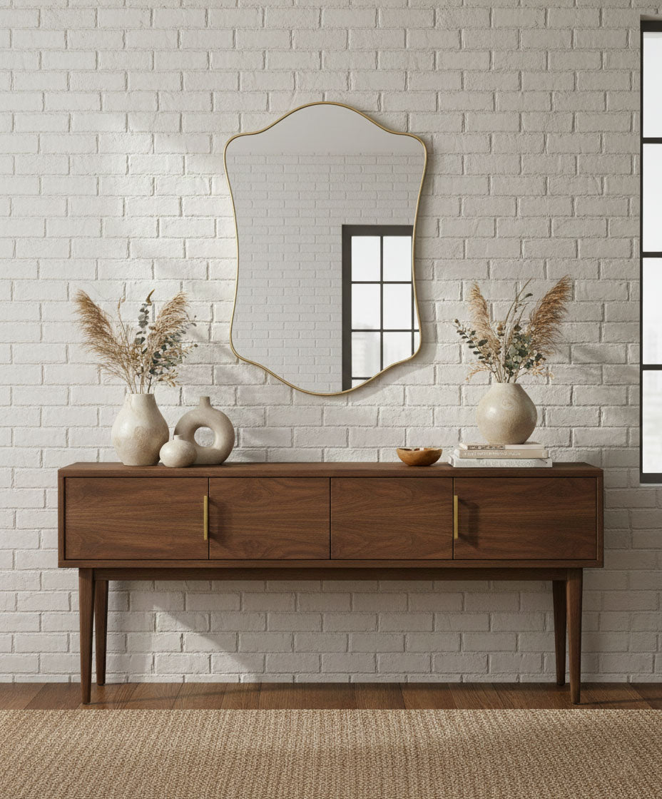Wavy shield brass mirror above wooden console