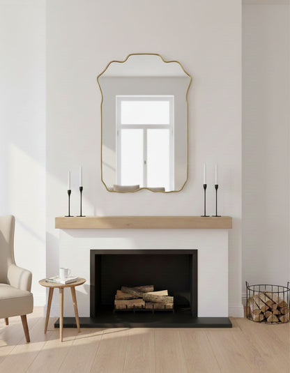 Brass crest wall mirror styled above fireplace mantel