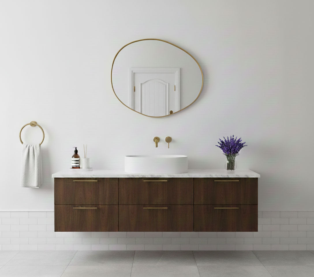 Raw edge brass mirror in a modern bathroom with wooden vanity