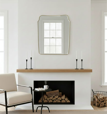 Rounded crest rectangle brass mirror displayed above a fireplace mantel
