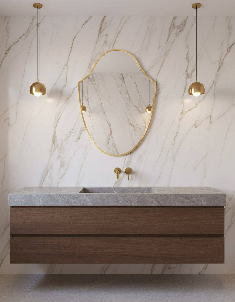 Bathroom vanity with marble wall, round mirror, and pendant lights.