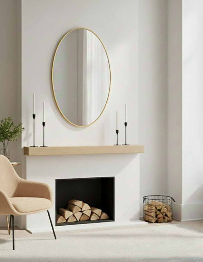 Oval brass wall mirror above modern fireplace