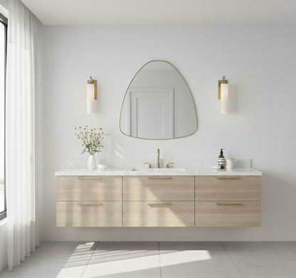 Organic pebble triangle brass mirror above floating wood vanity