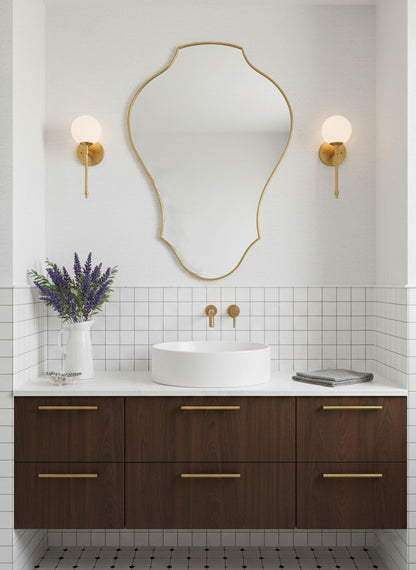 Tulip shield brass vanity mirror in modern bathroom interior