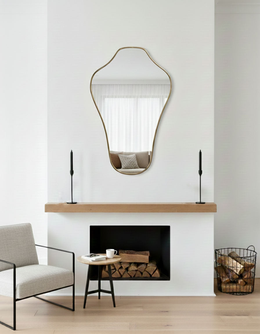 Sculpted crest wall mirror styled above modern fireplace mantel