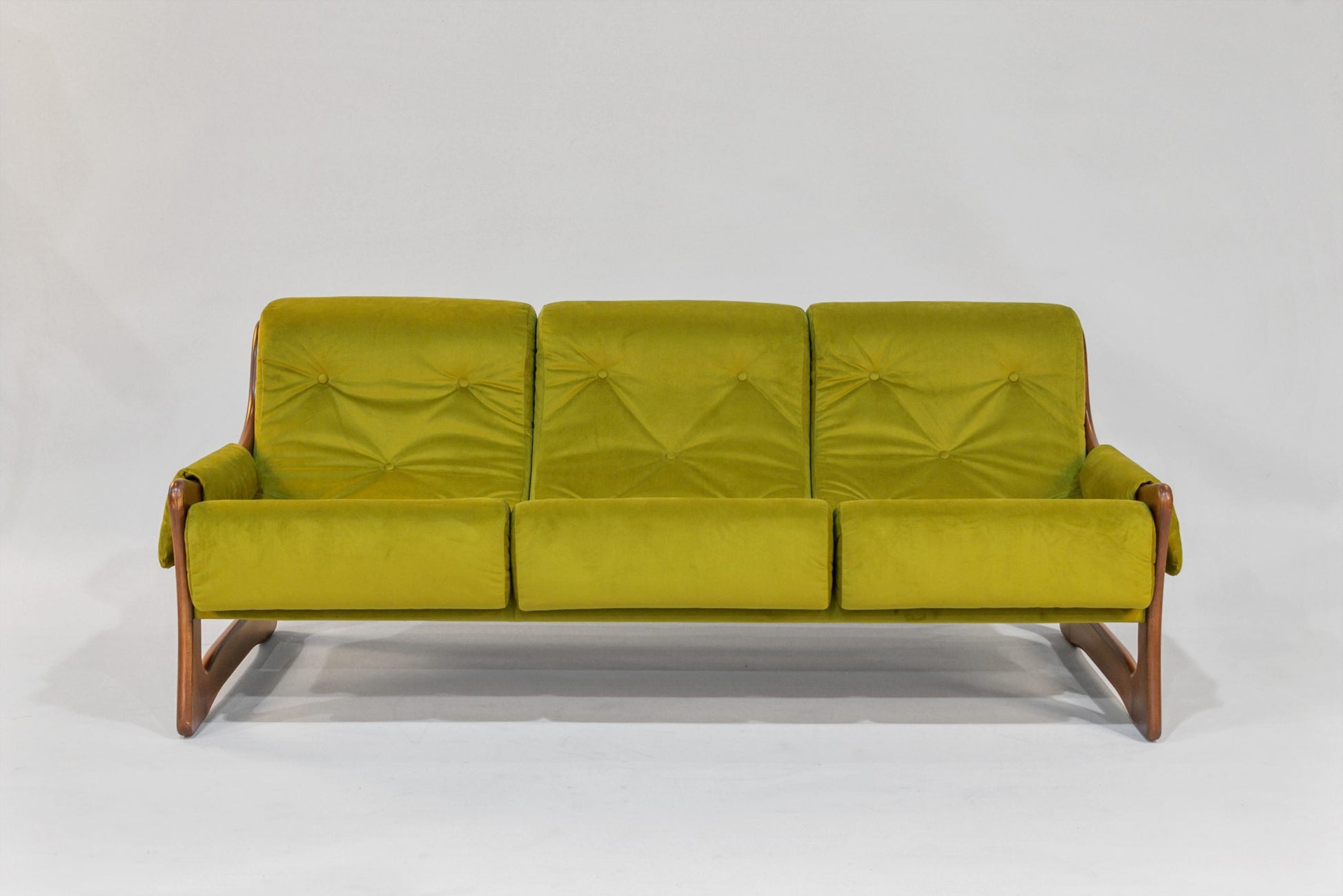 Green sofa with wooden frame on a white background