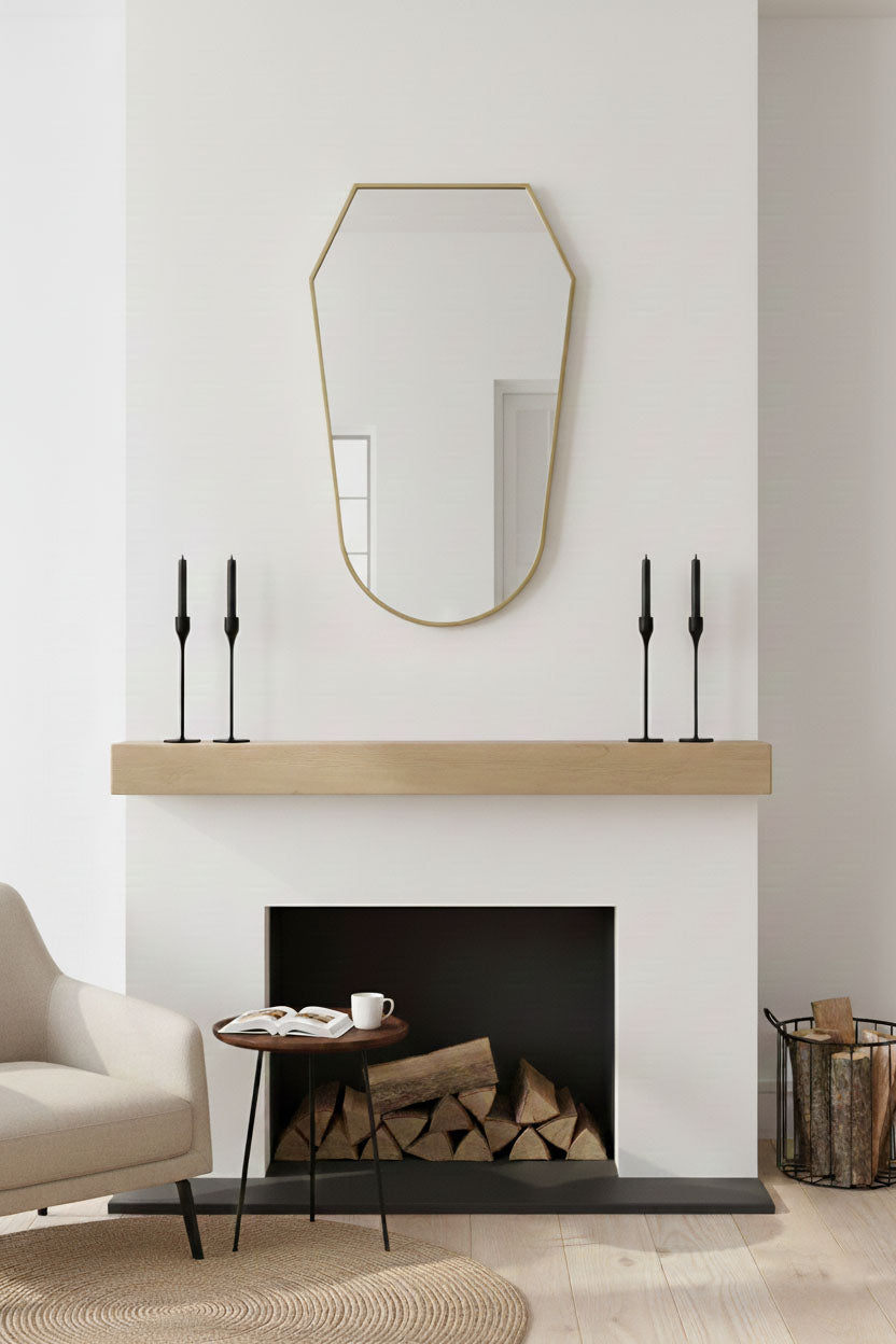 Rounded shield mirror with brass frame mounted above fireplace mantel