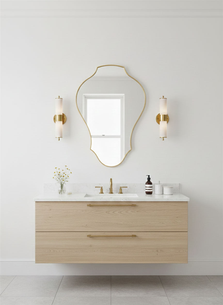 Organic tulip shield mirror with brass frame over floating vanity