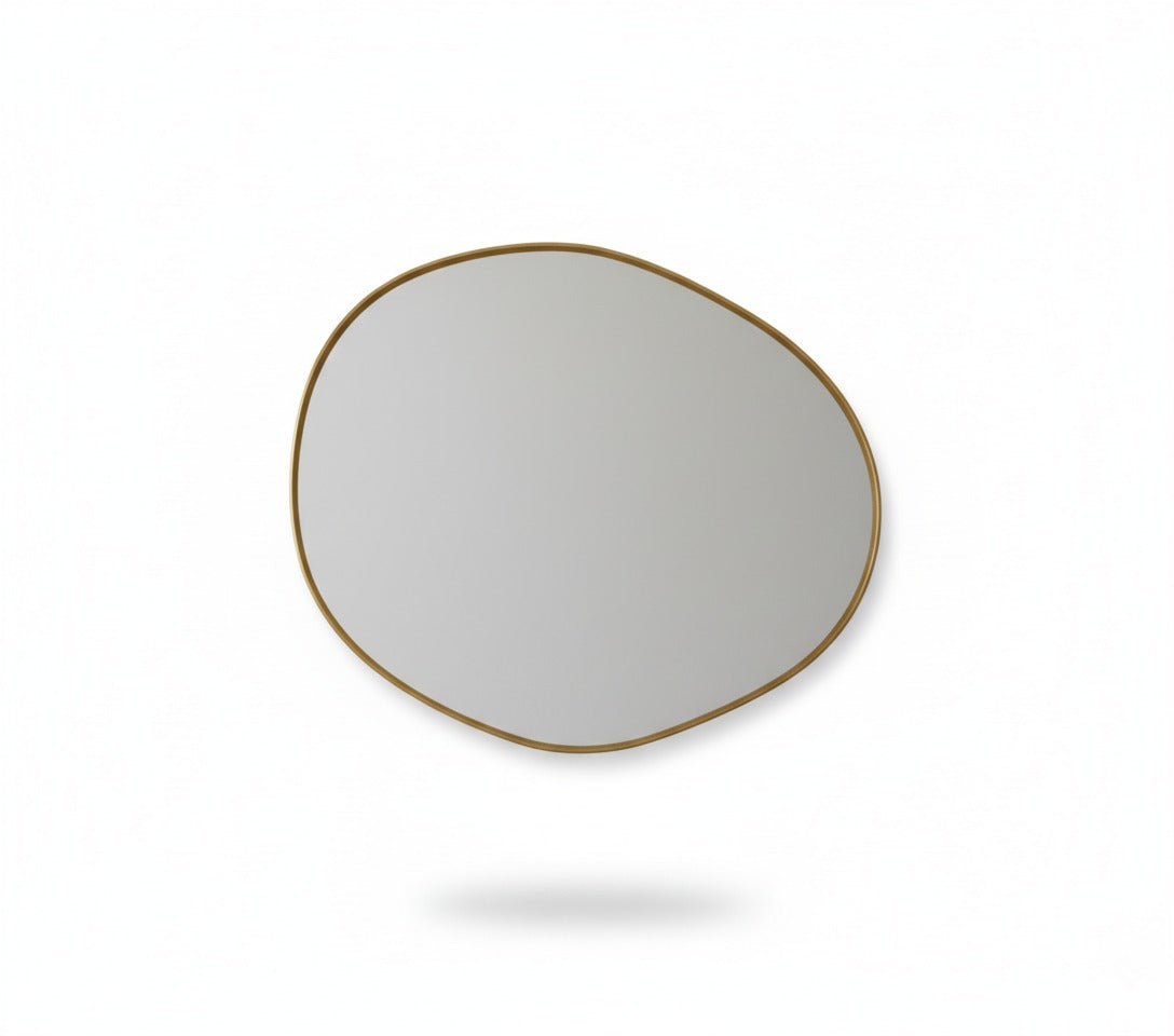 Raw edge brass mirror isolated on white background showing organic shape
