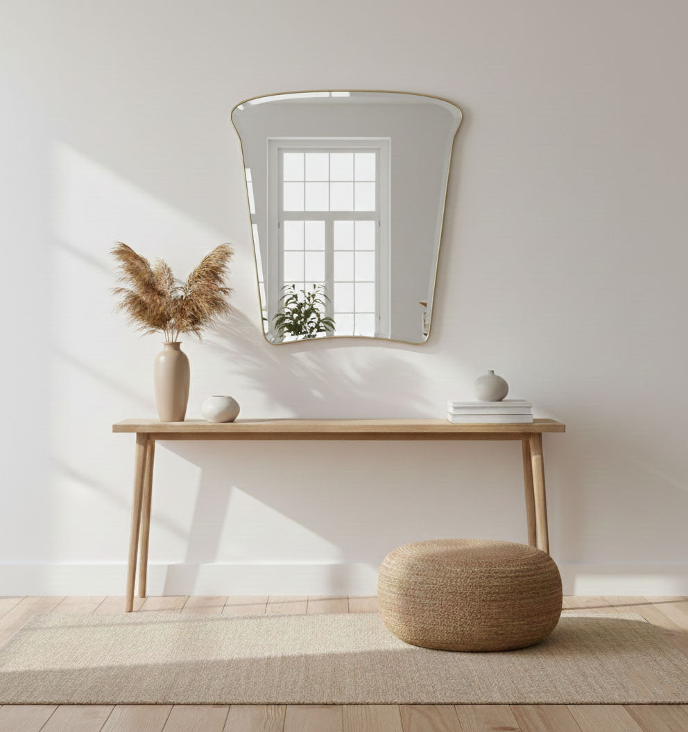 Tulip Crest brass mirror above console table in bright neutral interior