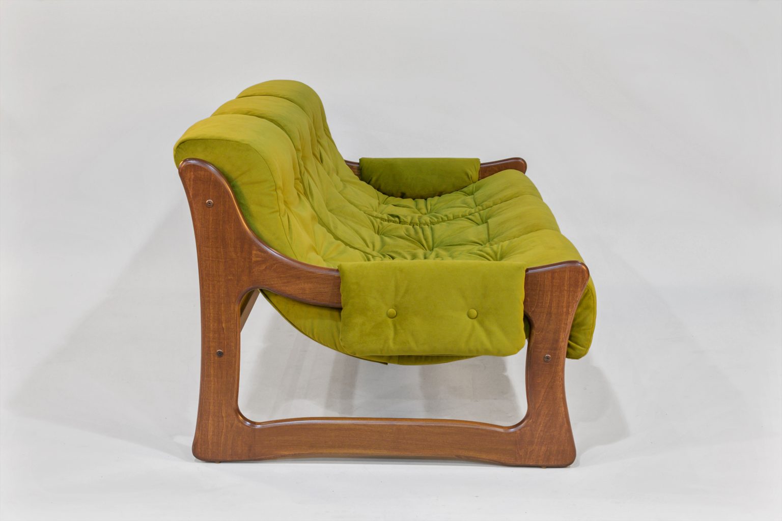 Green cushioned chair with wooden frame on a white background