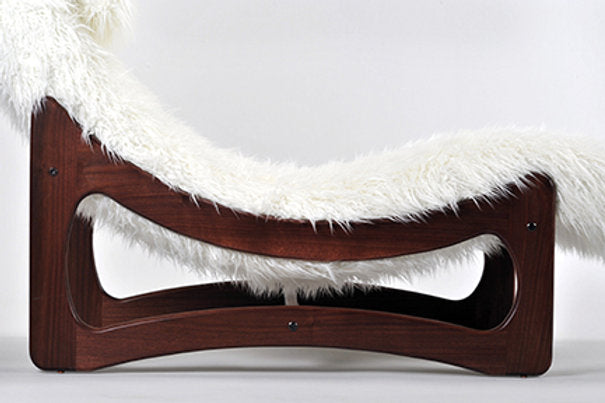 Wooden pet bed with white fur on a light gray background