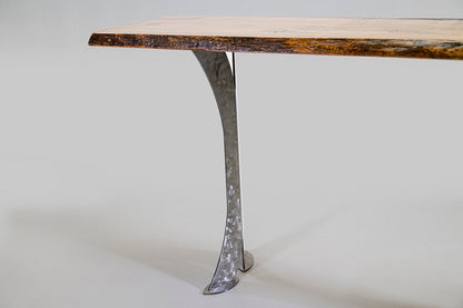 Wooden table with a unique metal leg on a white background