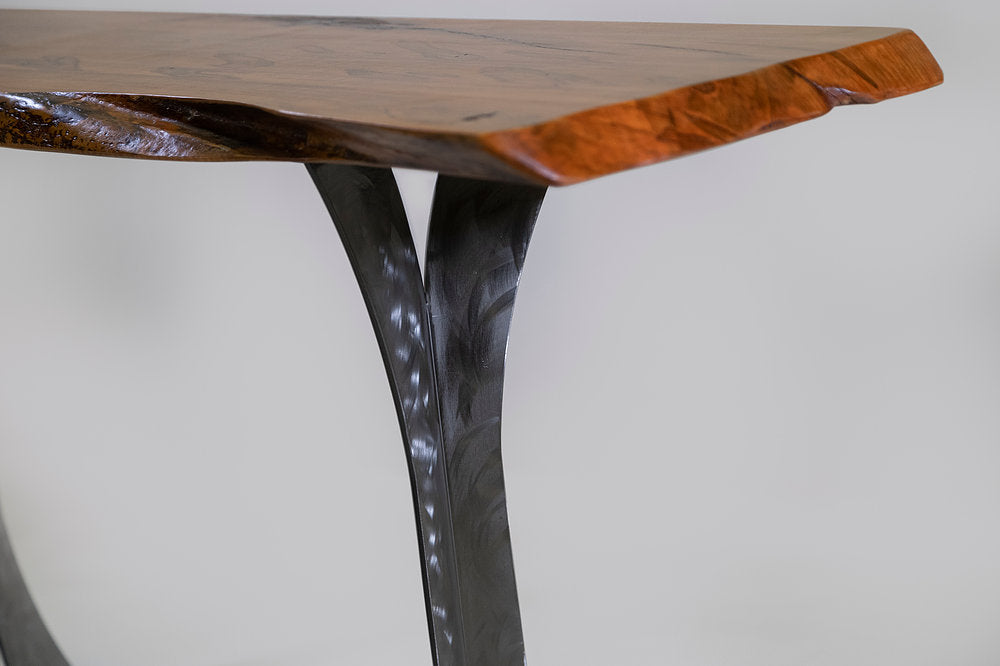 Wooden table with a dark metal leg on a white background