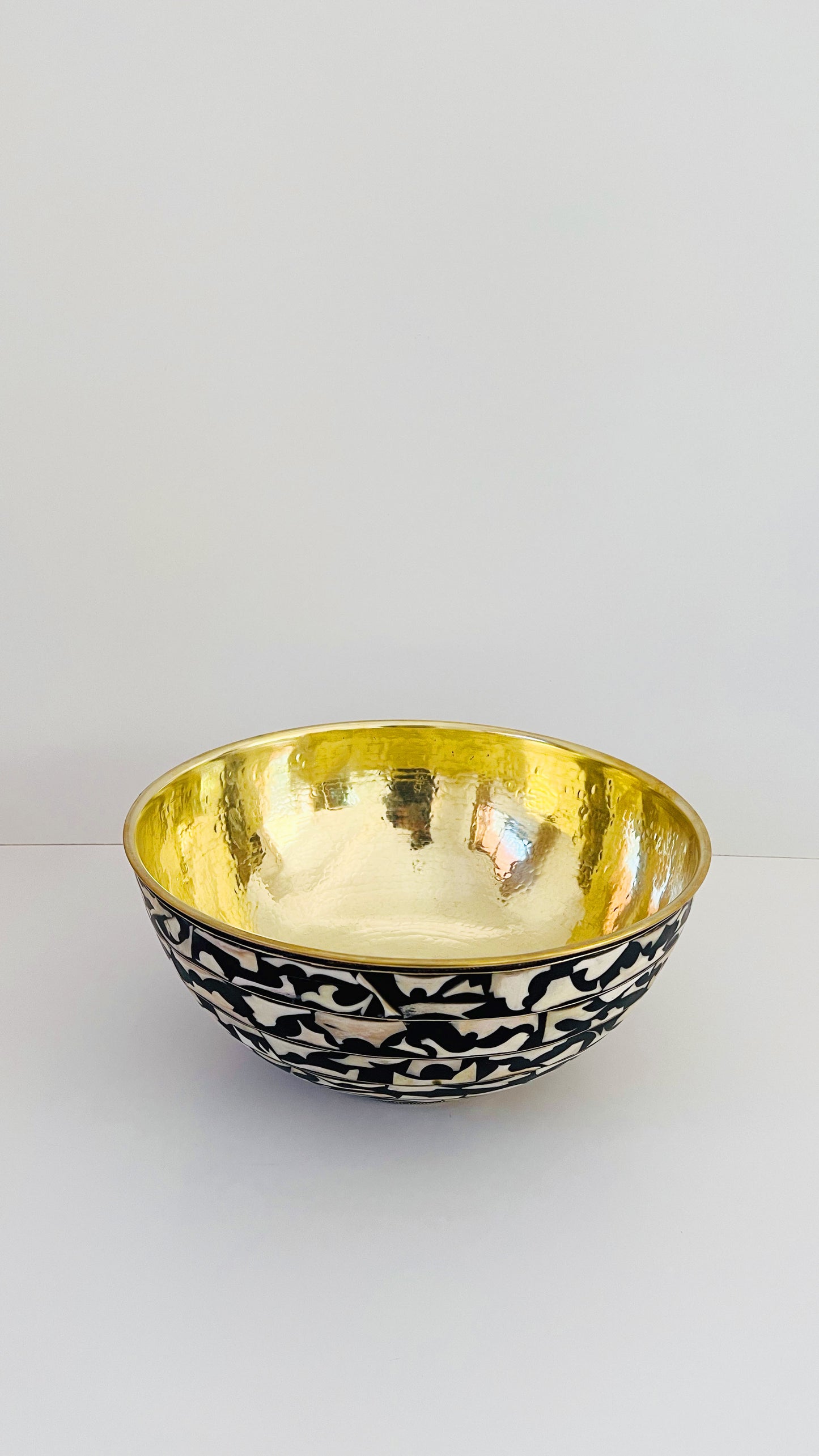 a gold and black basin sitting on top of a white table