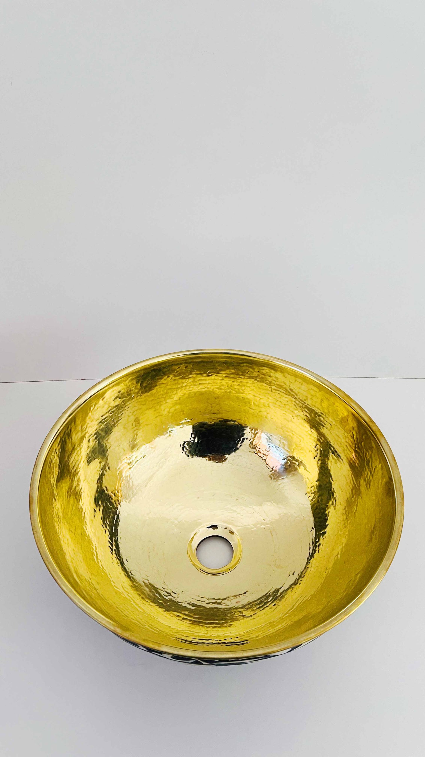 a gold bowl shaped sink on a white surface