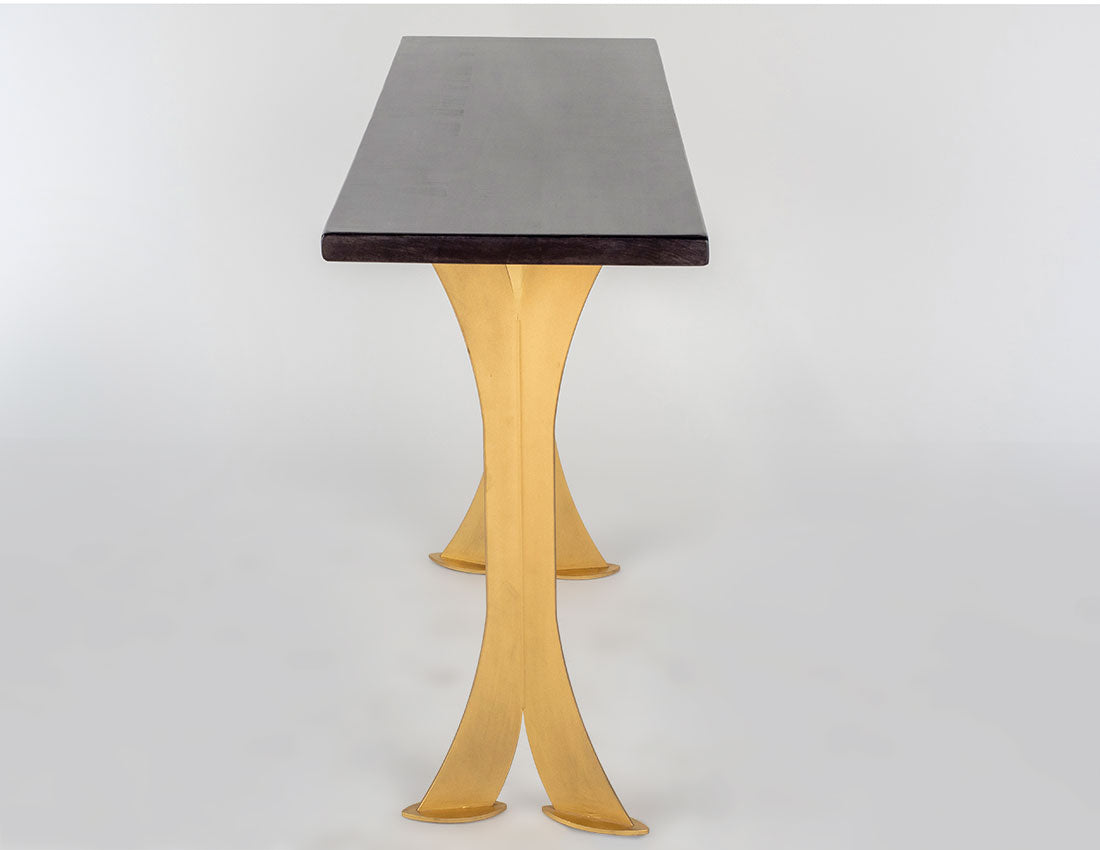 Table with a dark top and gold legs on a white background
