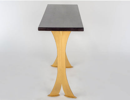 Table with a dark top and gold legs on a white background