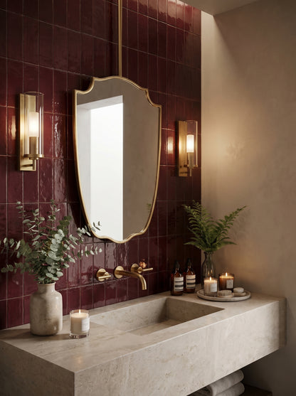 Handmade brass suspended mirror in a luxury bathroom with emerald green tiles and a floating concrete vanity.
