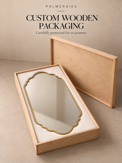 A custom wooden packaging box with a light natural wood frame and white interior cushioning, shown open with a decorative oval mirror inside. A second wooden box lid stands behind it on a beige studio surface.