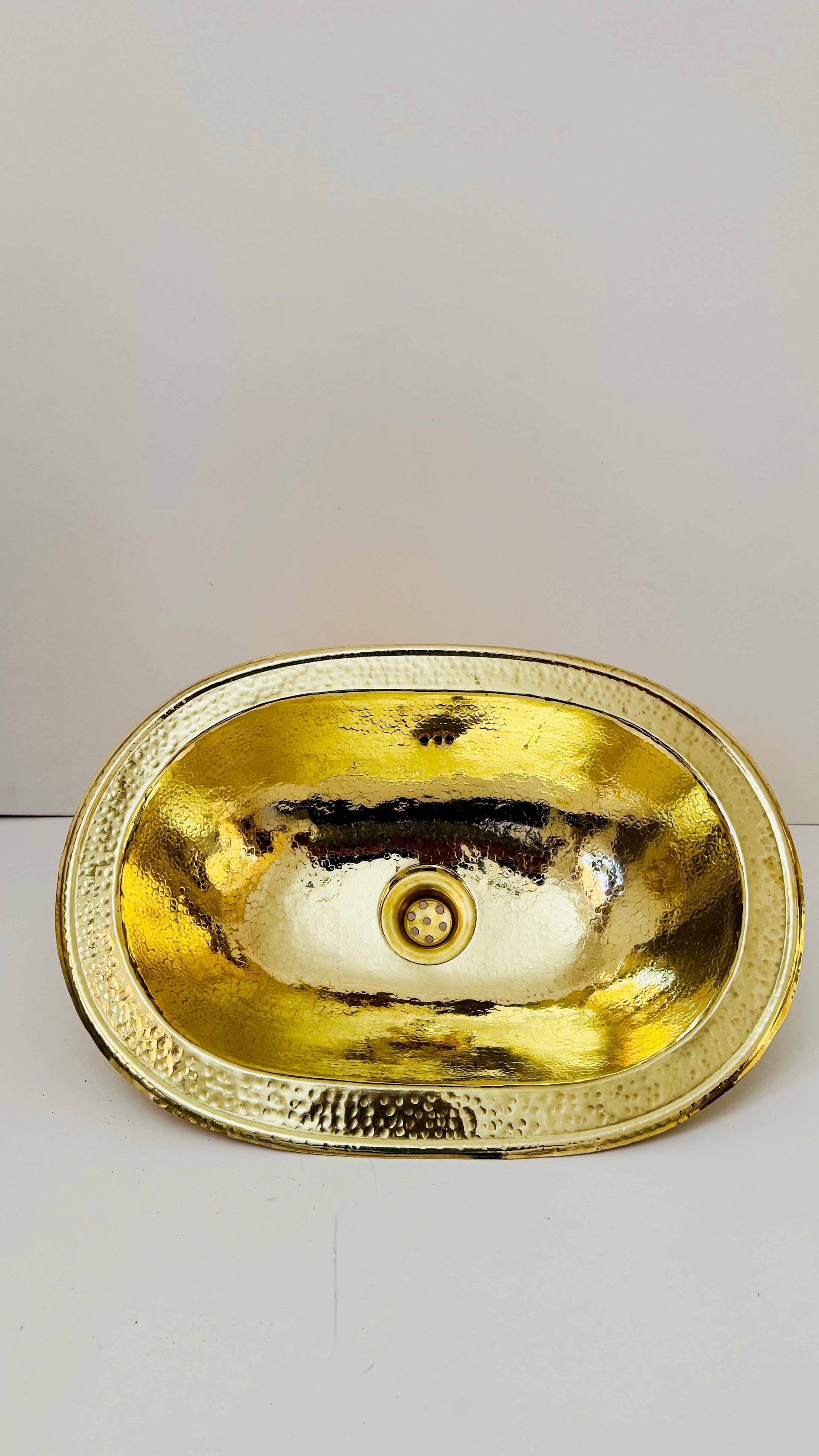 a gold sink on a white counter top