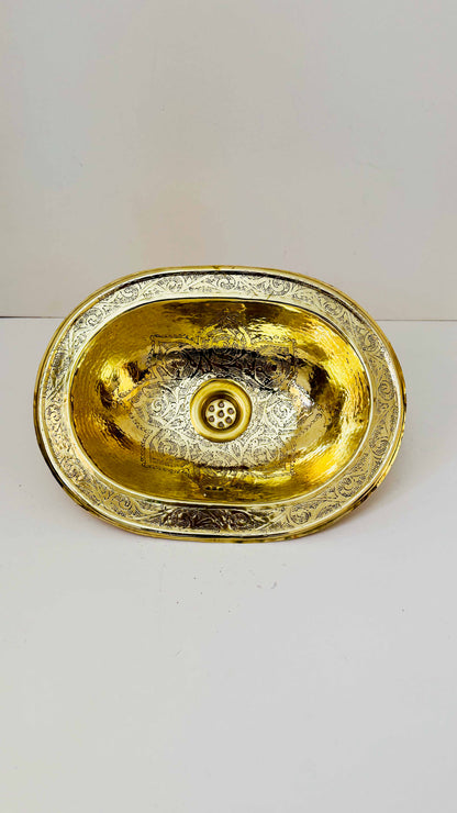 a golden sink on a white counter top