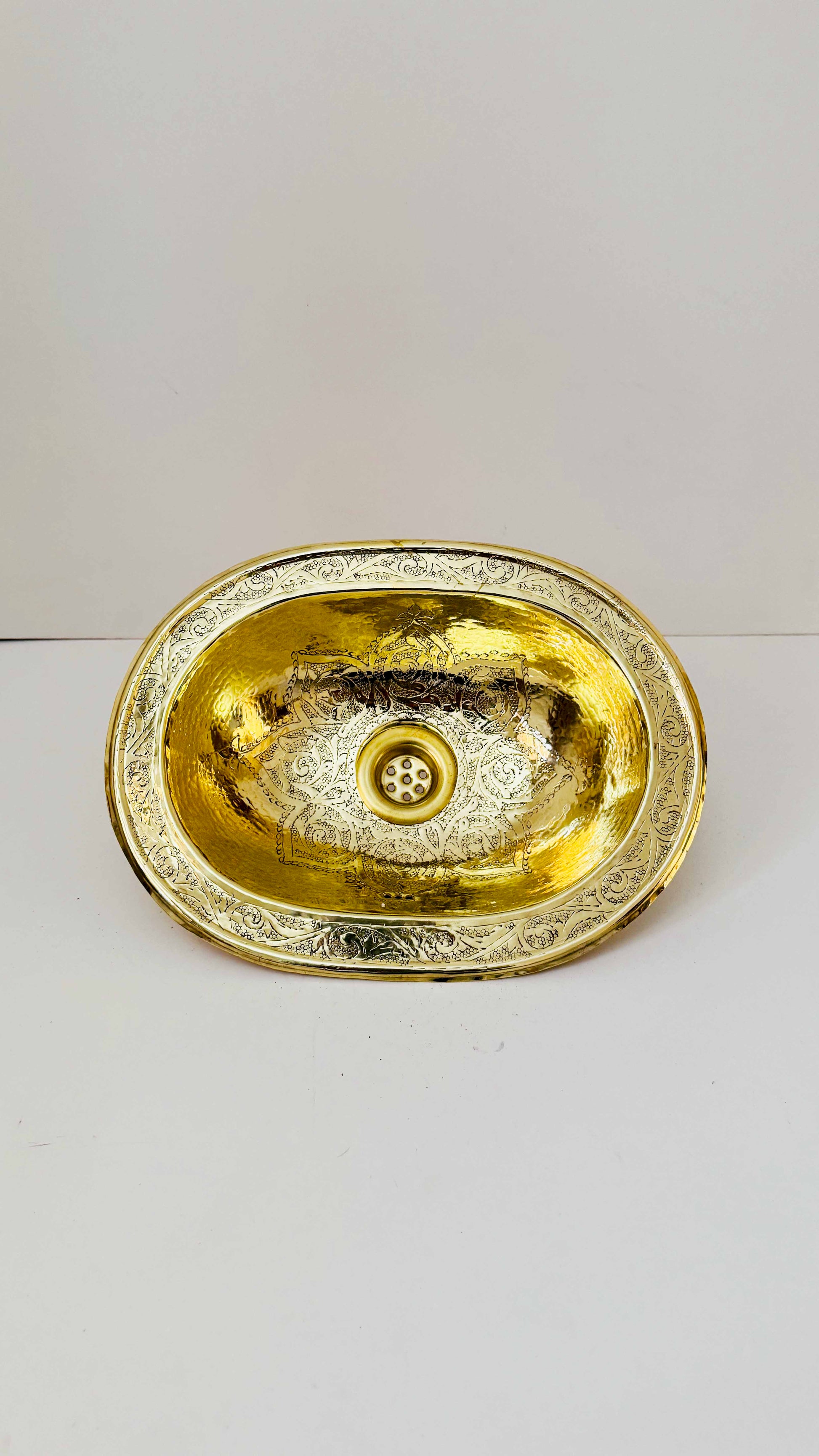 a golden bowl sitting on top of a white table