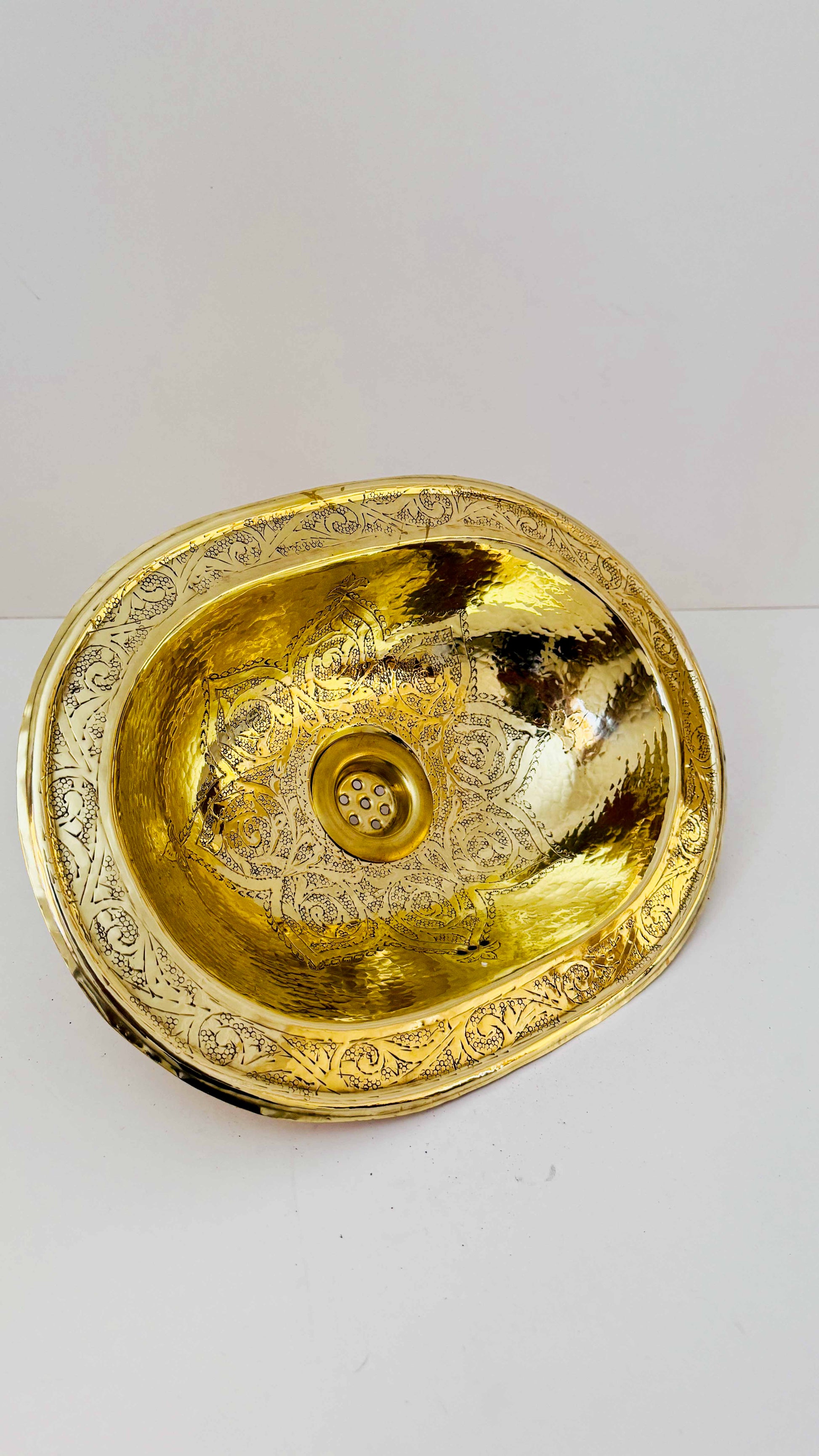 a golden bowl shaped sink sitting on top of a white counter