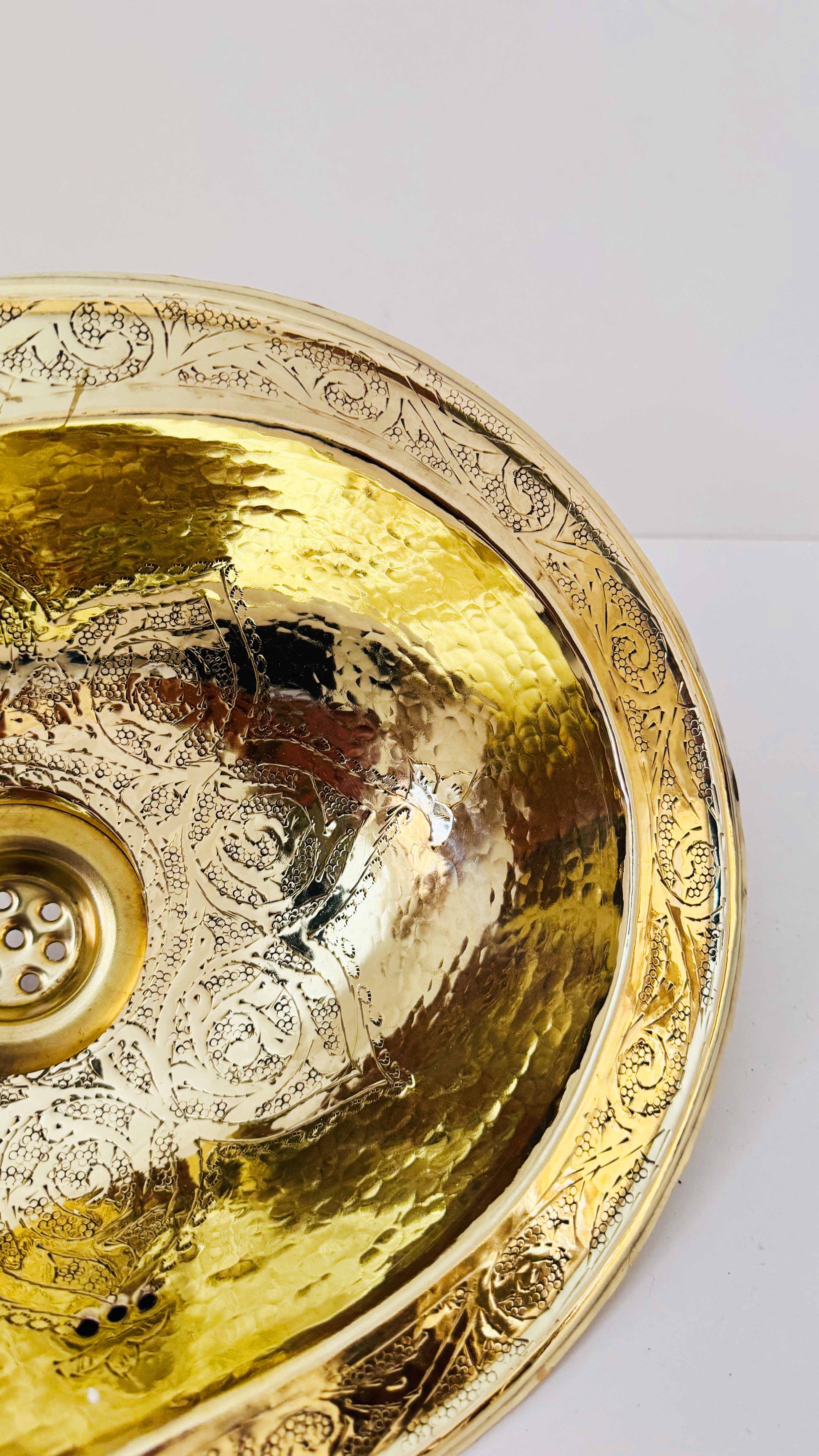 a golden bowl shaped sink on a white surface