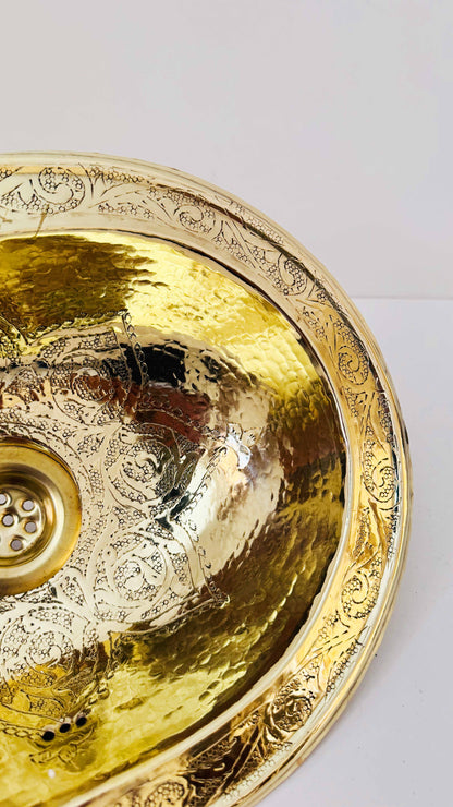 a golden bowl shaped sink on a white surface