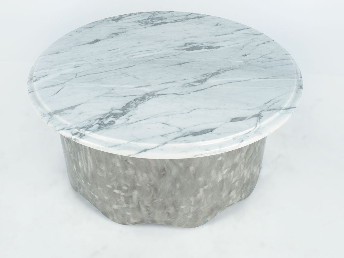 Round marble coffee table with a light gray and white pattern on a white background