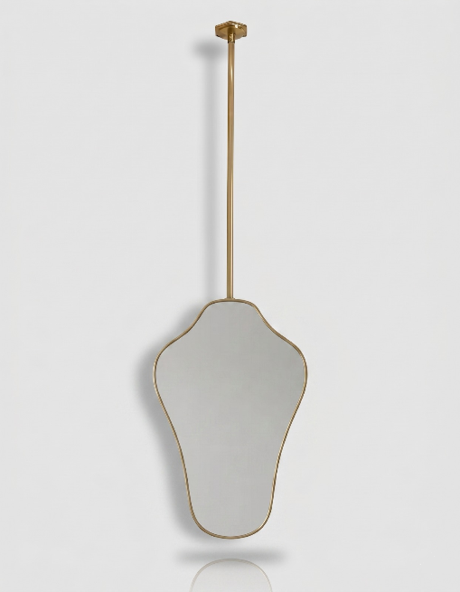 Suspended organic brass mirror with slim gold frame and ceiling-mounted brass rod.