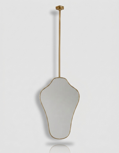 Suspended organic brass mirror with slim gold frame and ceiling-mounted brass rod.