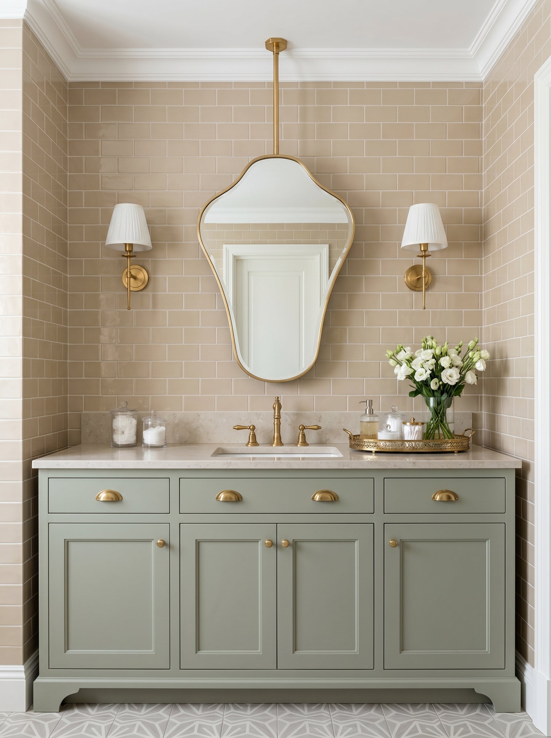 Ceiling-mounted organic brass mirror over a sage green vanity with classic brass sconces.