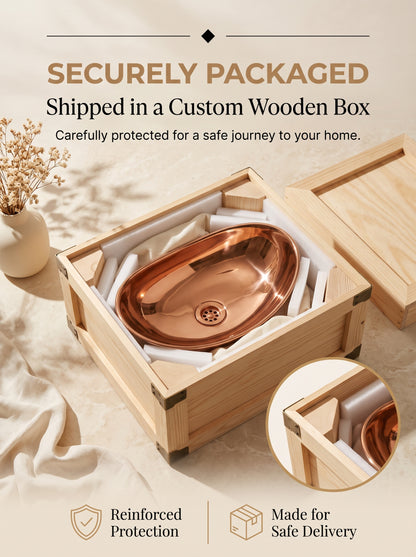 Oval copper vessel sink protected by white foam inside an open wooden shipping crate beneath “Securely Packaged” text.