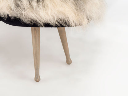 Fur-covered stool with wooden legs on a white background