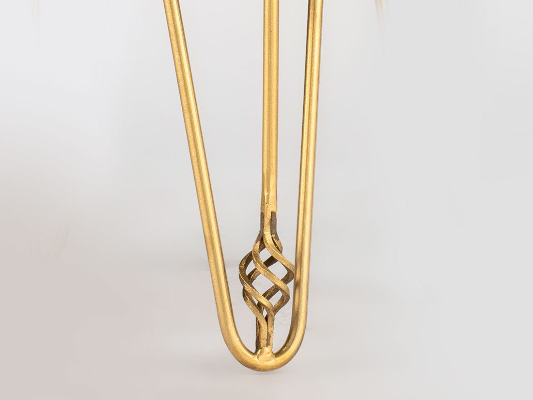Gold hair clip with intricate design on a light gray background