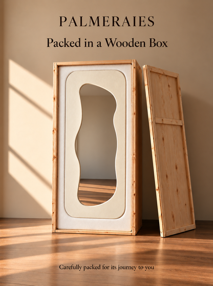 A wooden storage box or cabinet with a wavy cutout panel, shown packed and standing next to its wooden side panel in a warm interior setting. Text at the top reads 'PALMERAIES Packed in a Wooden Box' and text at the bottom says 'Carefully packed for its journey to you.