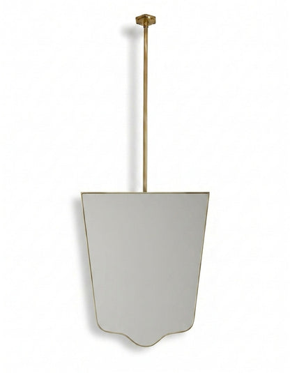 Handmade shield-shaped brass mirror with ceiling-mounted brass rod on a white background.