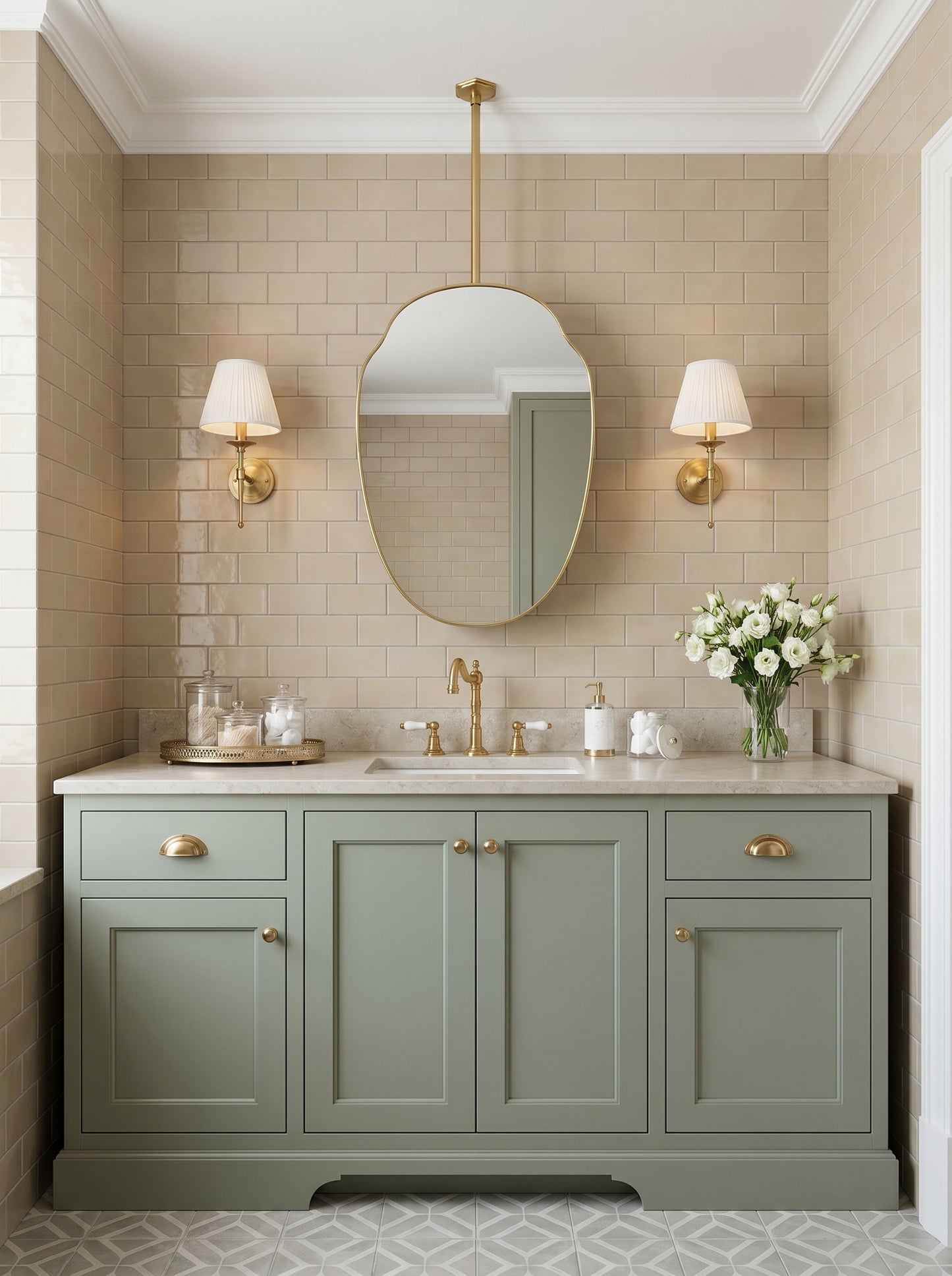 Organic brass hanging mirror over a sage green vanity with brass fixtures.