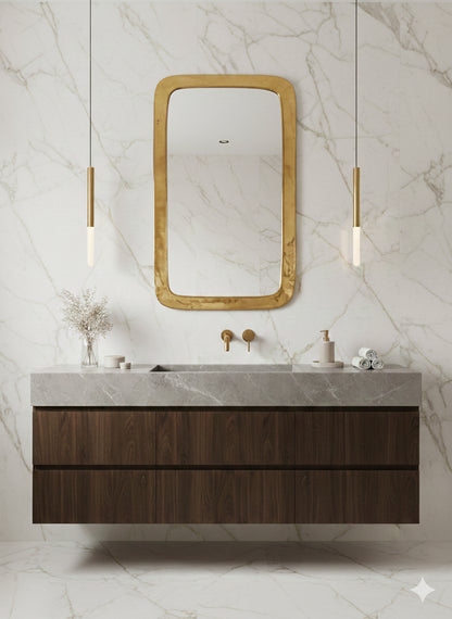 Brass mirror above wooden bathroom vanity