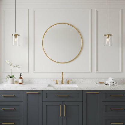 Round brass mirror centered above navy vanity with marble top