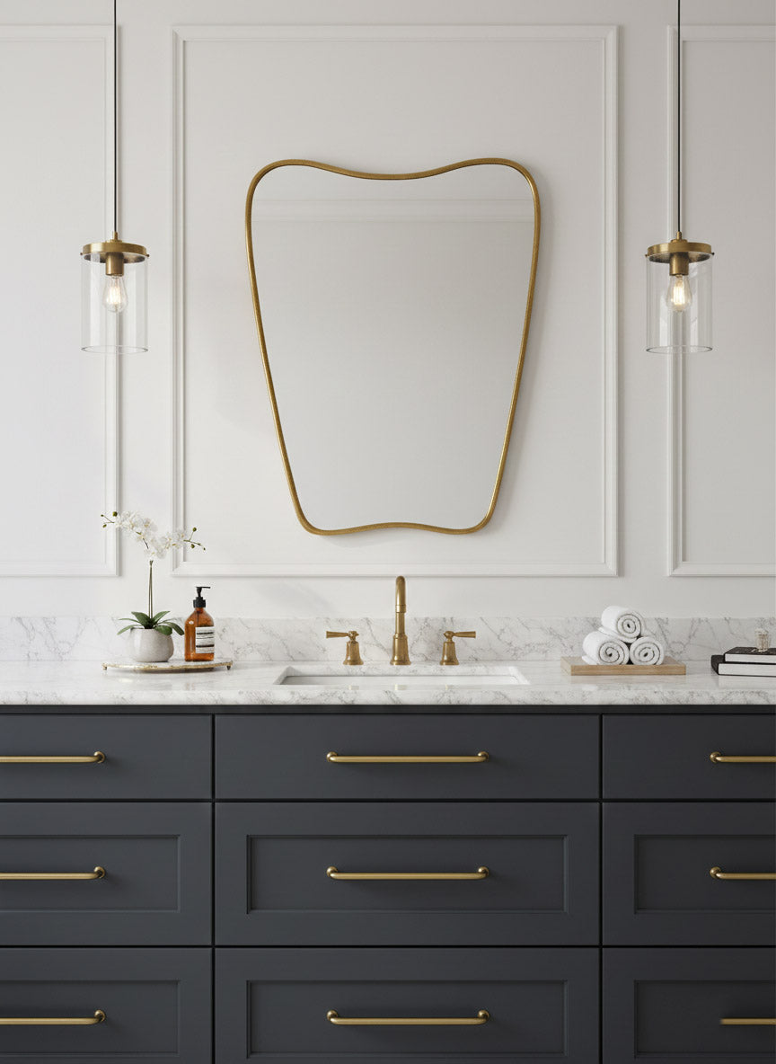 Italian curved brass mirror centered above navy bathroom vanity