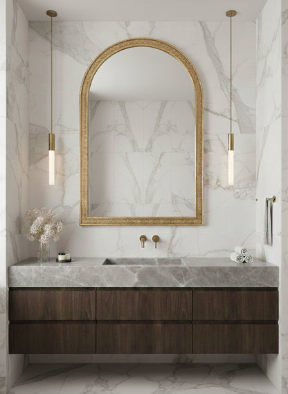Large brass arch mirror above marble vanity