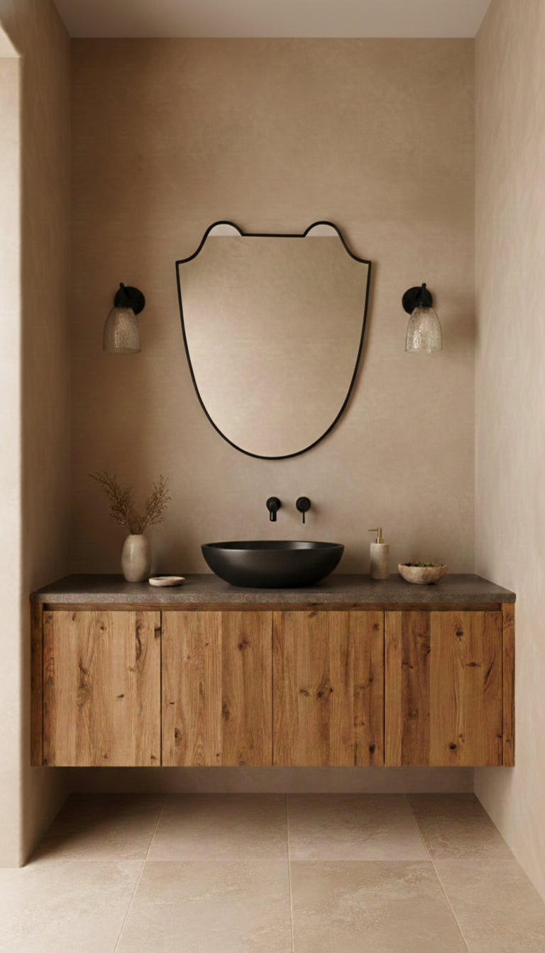 Black brass Italian shield mirror above a wooden bathroom vanity