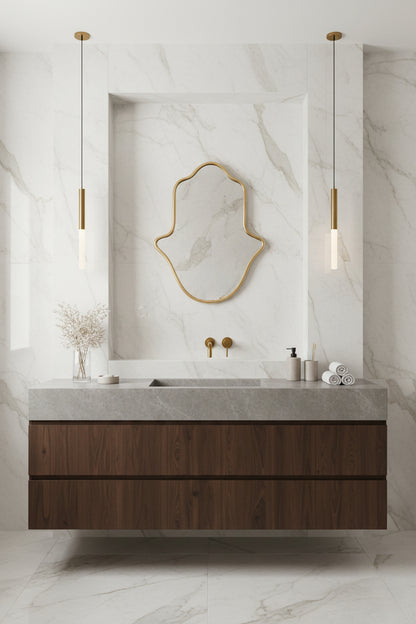 Handmade brass Hamsa mirror on white marble bathroom wall