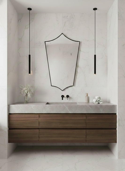 Brass mirror above bathroom vanity